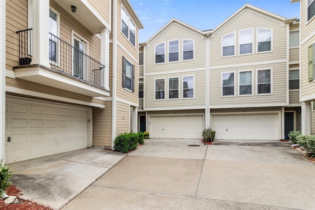 multi unit property featuring driveway and an attached garage