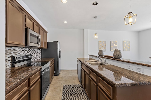 kitchen featuring appliances with stainless steel finishes, backsplash, a sink, and pendant lighting