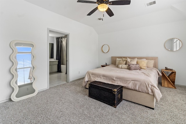 bedroom featuring visible vents, vaulted ceiling, carpet flooring, and ensuite bathroom