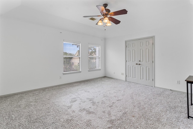 unfurnished bedroom featuring carpet floors, a closet, visible vents, and ceiling fan