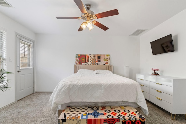 carpeted bedroom with a ceiling fan and visible vents