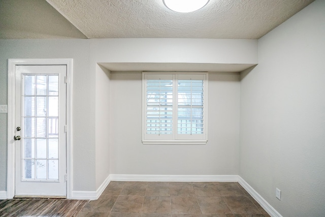 interior space with a textured ceiling and baseboards