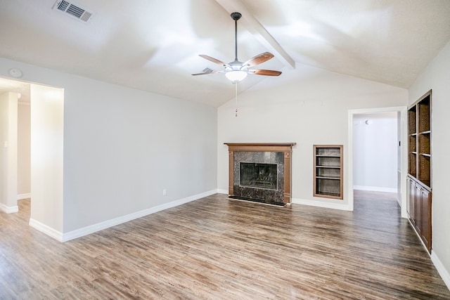 unfurnished living room featuring vaulted ceiling with beams, wood finished floors, visible vents, and a high end fireplace