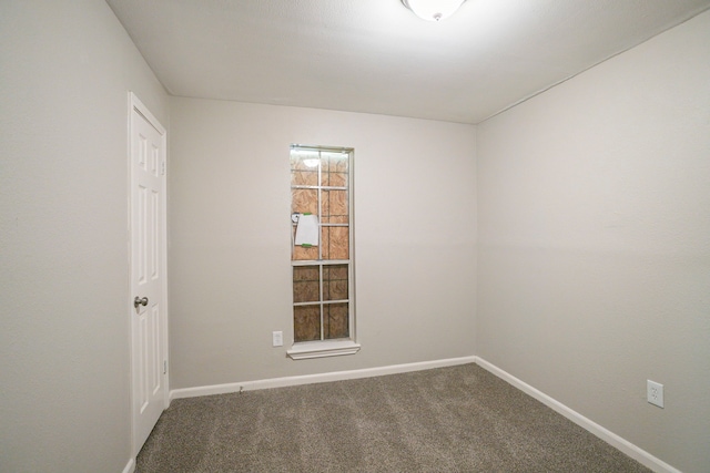 spare room featuring carpet and baseboards