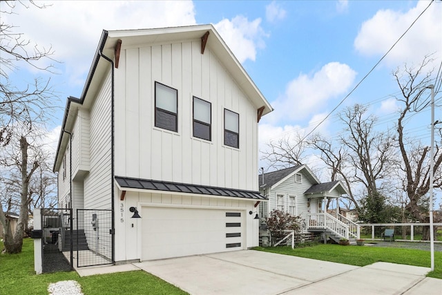 view of front of home with metal roof, concrete driveway, board and batten siding, a standing seam roof, and a front yard