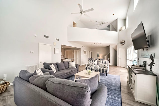 living area with light wood finished floors, visible vents, and a ceiling fan