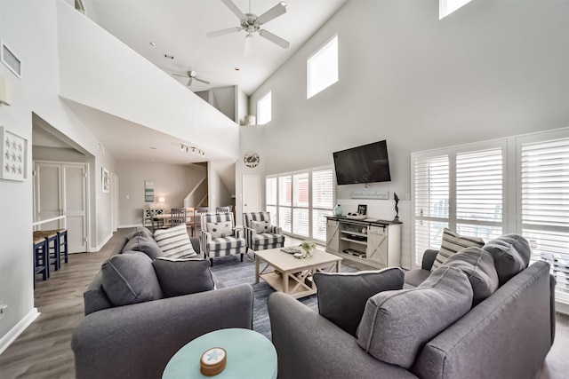 living room featuring baseboards, visible vents, a ceiling fan, and wood finished floors