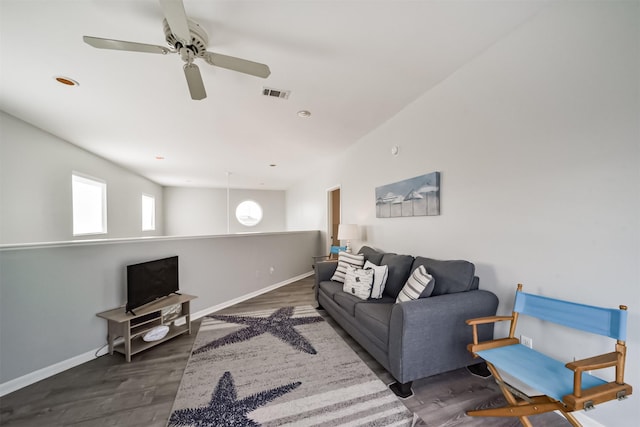 living area with dark wood finished floors, visible vents, and baseboards