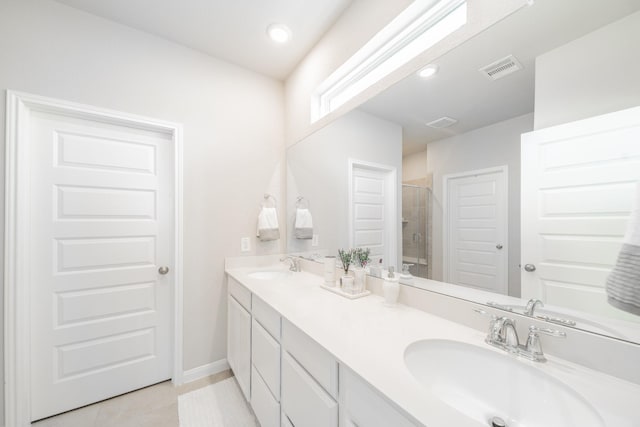 bathroom featuring double vanity, visible vents, a sink, and tile patterned floors