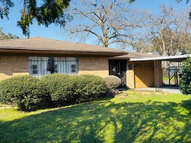 view of front of home with driveway, a front lawn, an attached garage, and brick siding