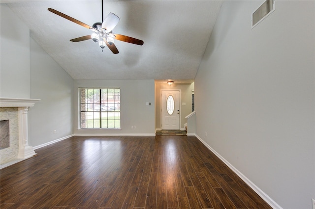 unfurnished living room with dark wood-style floors, a fireplace, visible vents, vaulted ceiling, and baseboards