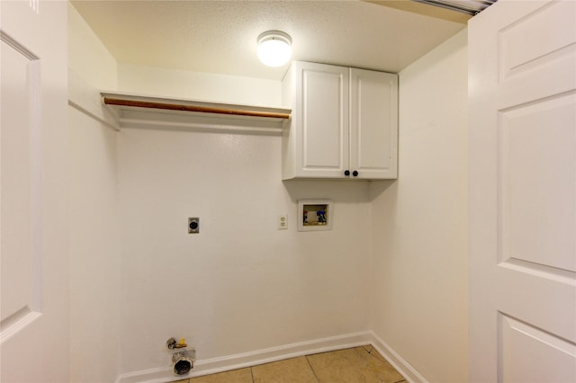 clothes washing area featuring light tile patterned floors, hookup for a washing machine, cabinet space, electric dryer hookup, and baseboards