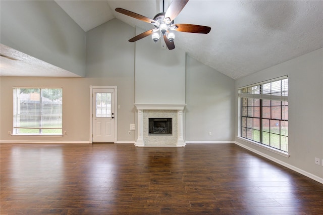 unfurnished living room featuring a fireplace with flush hearth, dark wood finished floors, and baseboards