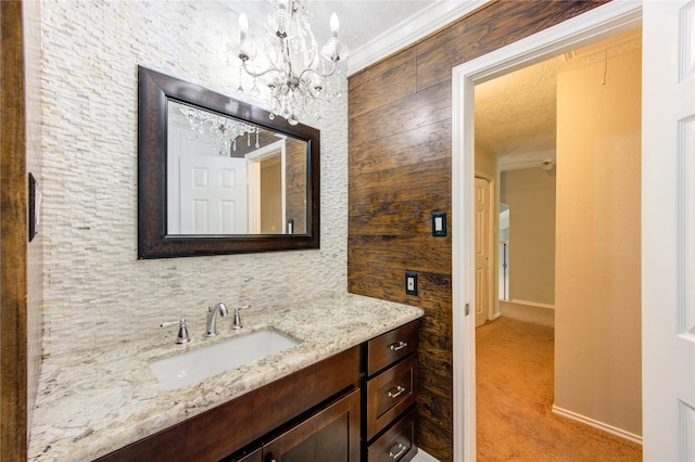 bathroom with baseboards, ornamental molding, and vanity