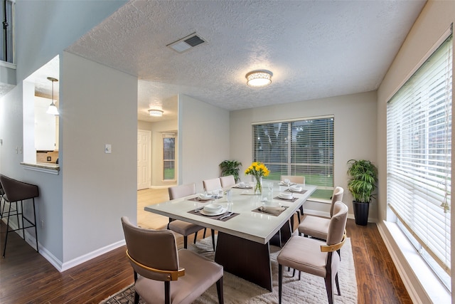 dining room featuring baseboards, visible vents, and dark wood finished floors