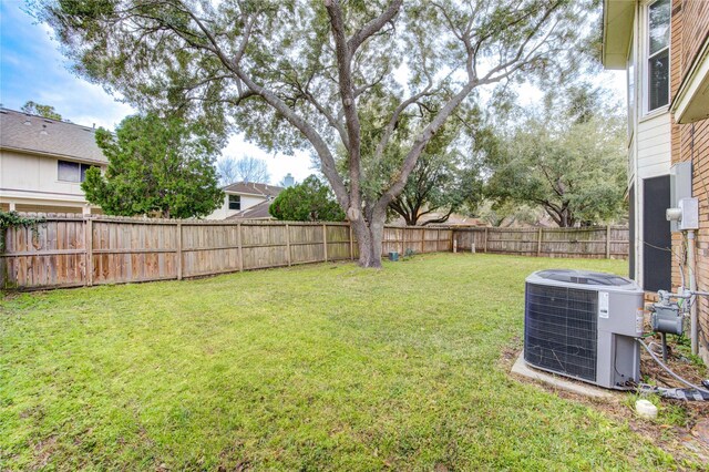 view of yard with central air condition unit and a fenced backyard
