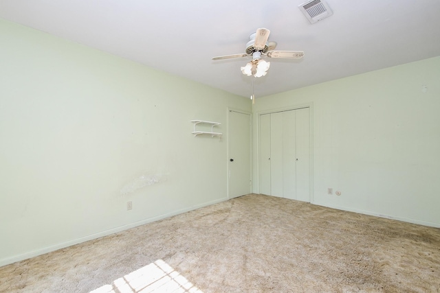 empty room with ceiling fan, baseboards, visible vents, and light colored carpet