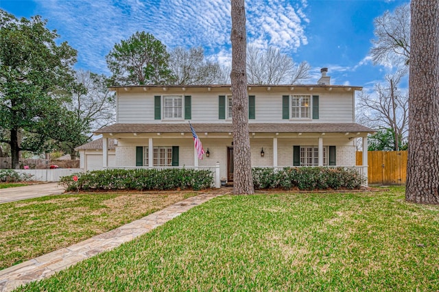 traditional-style house with covered porch, fence, concrete driveway, and brick siding