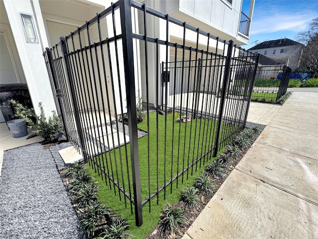 view of gate with fence and a yard