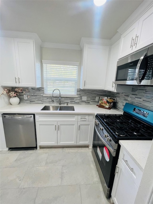 kitchen with a sink, white cabinetry, light countertops, appliances with stainless steel finishes, and decorative backsplash