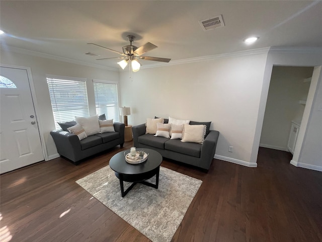 living room featuring dark wood-type flooring, visible vents, crown molding, and baseboards