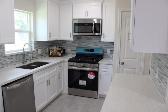 kitchen featuring light countertops, appliances with stainless steel finishes, a sink, and white cabinets