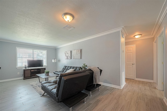 living area featuring light wood-style floors, visible vents, ornamental molding, and a textured ceiling