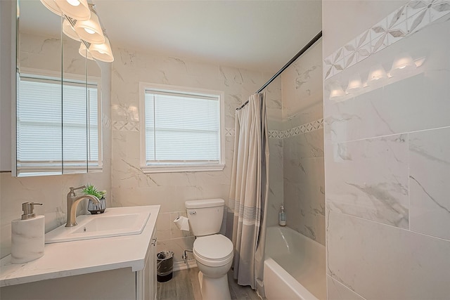 bathroom with shower / bath combo, toilet, wood finished floors, vanity, and tile walls