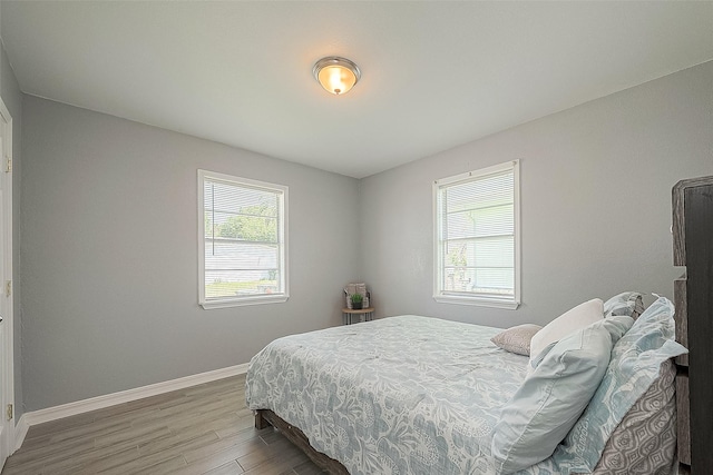 bedroom with wood finished floors and baseboards