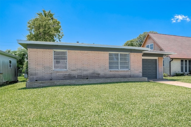 view of front of home featuring a front yard, concrete driveway, brick siding, and an attached garage