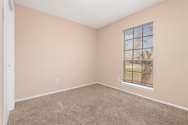 carpeted empty room with baseboards