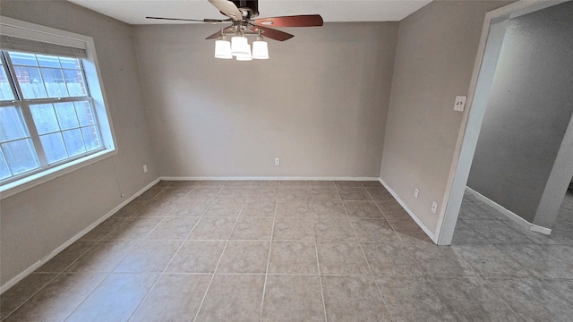 empty room with light tile patterned floors, ceiling fan, and baseboards