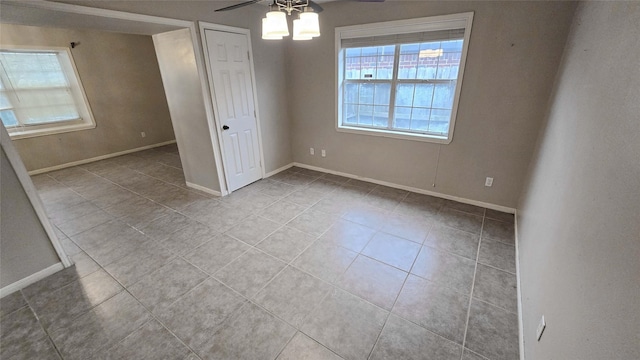 unfurnished bedroom with light tile patterned floors, baseboards, and a ceiling fan