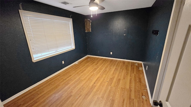 unfurnished room with light wood finished floors, visible vents, baseboards, and a ceiling fan