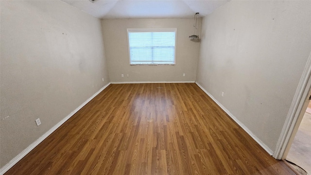 unfurnished room featuring dark wood-style flooring and baseboards