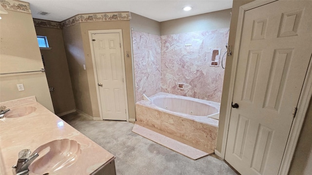 bathroom with a sink, a jetted tub, baseboards, and double vanity