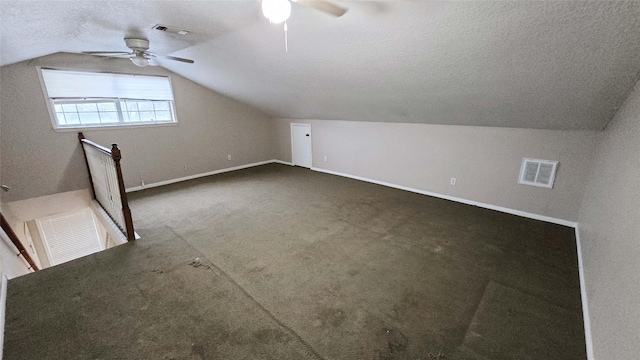 bonus room with visible vents, vaulted ceiling, a textured ceiling, and baseboards