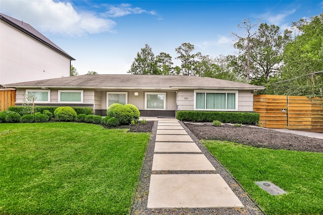 single story home with a front yard and fence