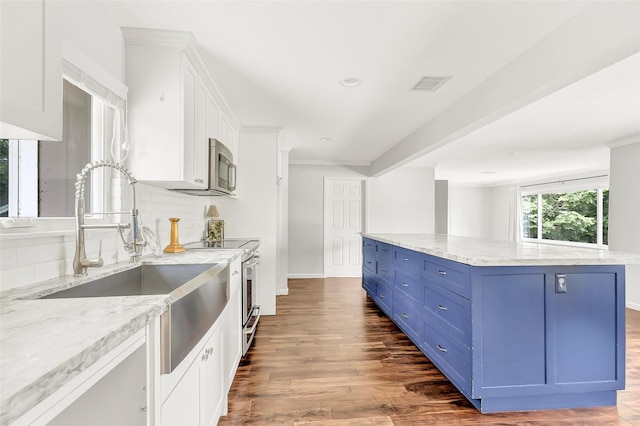 kitchen with stainless steel appliances, visible vents, white cabinetry, decorative backsplash, and dark wood-style floors