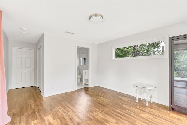 empty room featuring a healthy amount of sunlight, light wood-style flooring, and baseboards