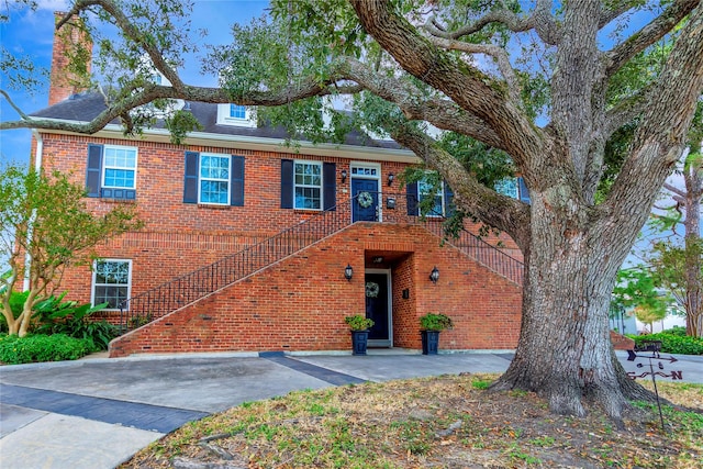 view of front of property featuring brick siding and stairway