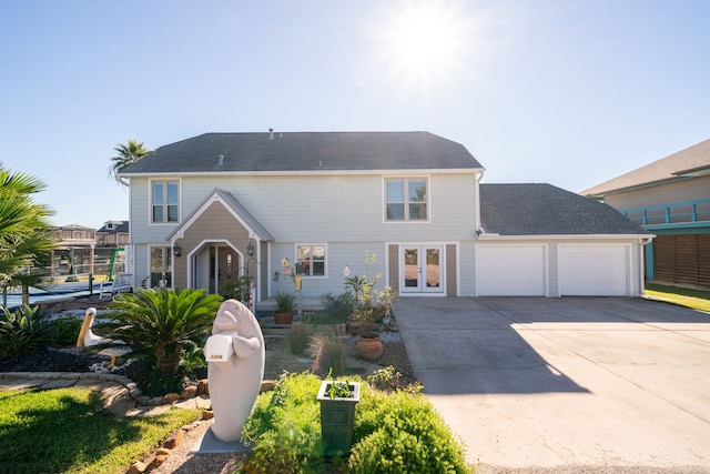 view of front facade featuring a garage, concrete driveway, and french doors