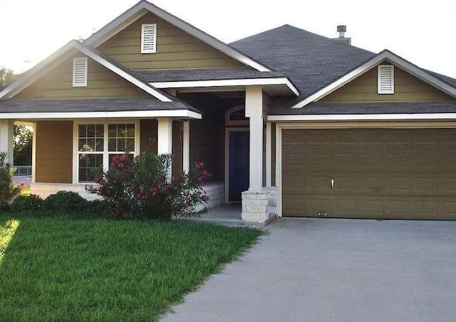 craftsman inspired home featuring a garage, driveway, and a front lawn