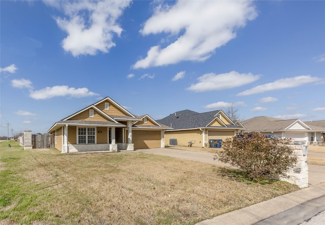 view of front of home with a garage, a front yard, concrete driveway, and fence