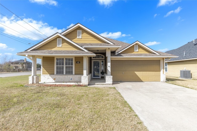 craftsman-style home with an attached garage, a front lawn, cooling unit, and concrete driveway