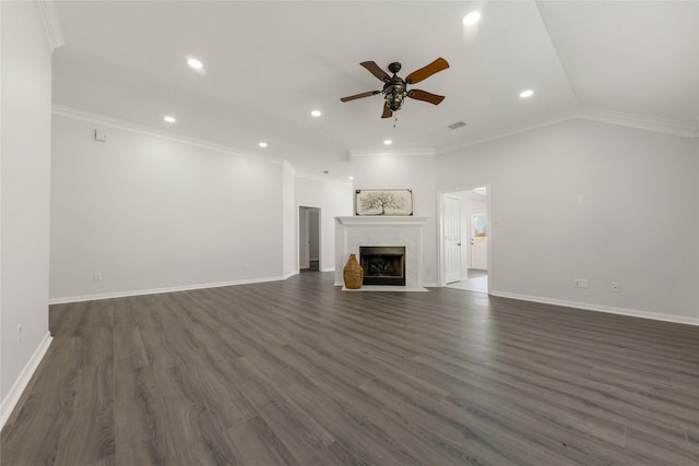 unfurnished living room featuring lofted ceiling, dark wood finished floors, a high end fireplace, and crown molding