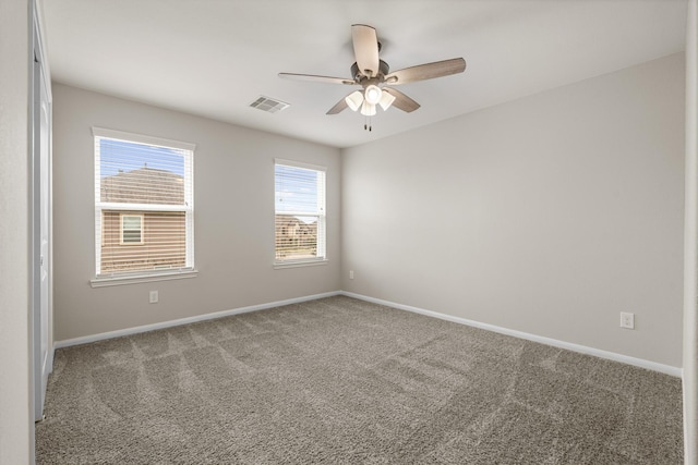 spare room with carpet floors, visible vents, baseboards, and a ceiling fan