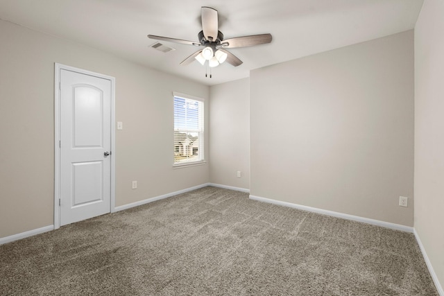 spare room with carpet flooring, visible vents, and baseboards