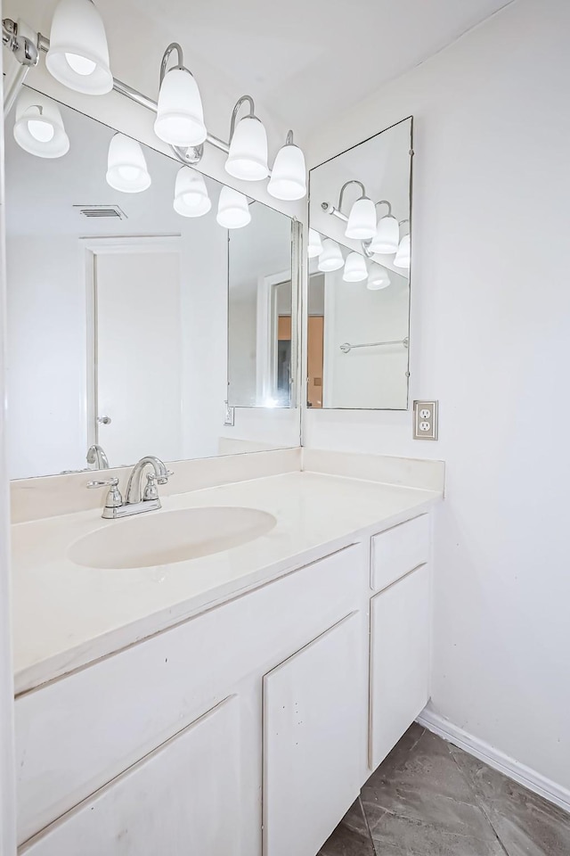 bathroom with baseboards, visible vents, and vanity