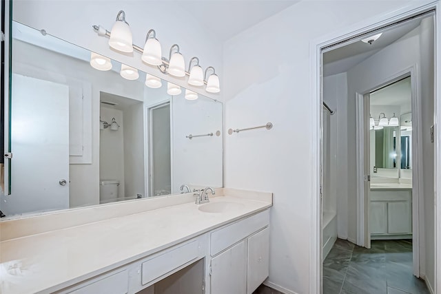 bathroom with toilet, marble finish floor, and vanity